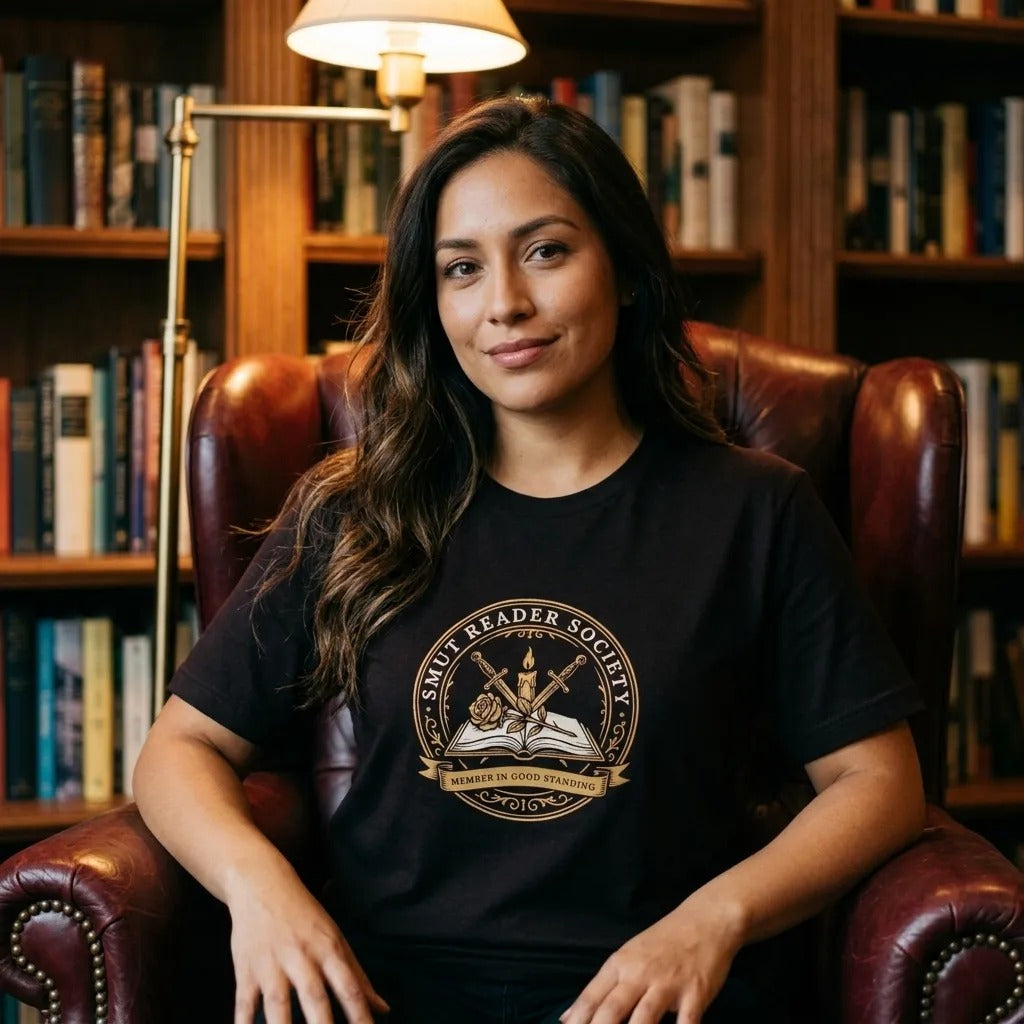 Smut Reader Society book lover tee, Latina woman reading in a home library wearing oxblood — Brown block