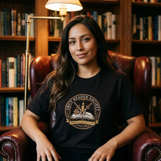 Smut Reader Society book lover tee, Latina woman reading in a home library wearing oxblood — Oxblood Black block