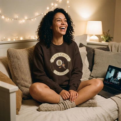 True Crime and Chill crewneck — woman relaxing on a daybed with a paused documentary, dark chocolate sweatshirt