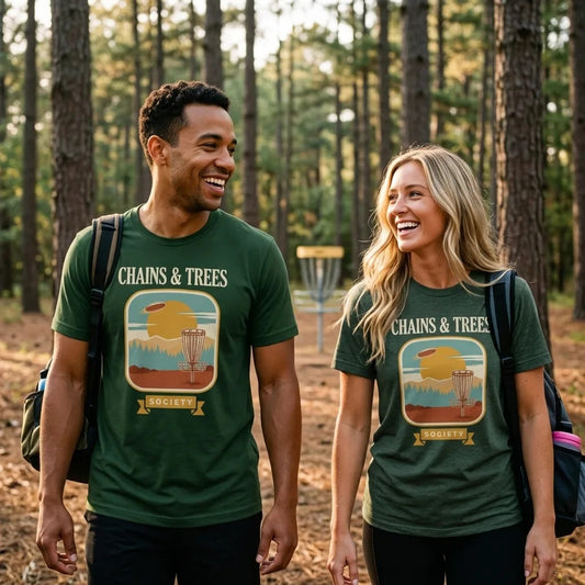 Chains & Trees Society disc golf retro landscape tee — two friends on a wooded disc golf fairway, Forest and Heather Forest