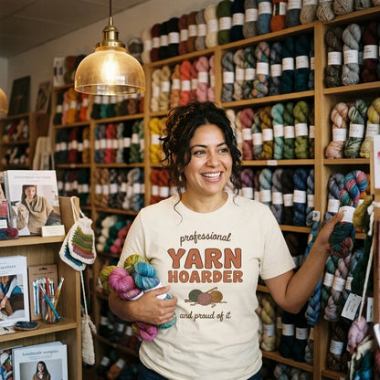 Latina woman in an indie yarn shop wearing the Professional Yarn Hoarder crochet tee in Natural