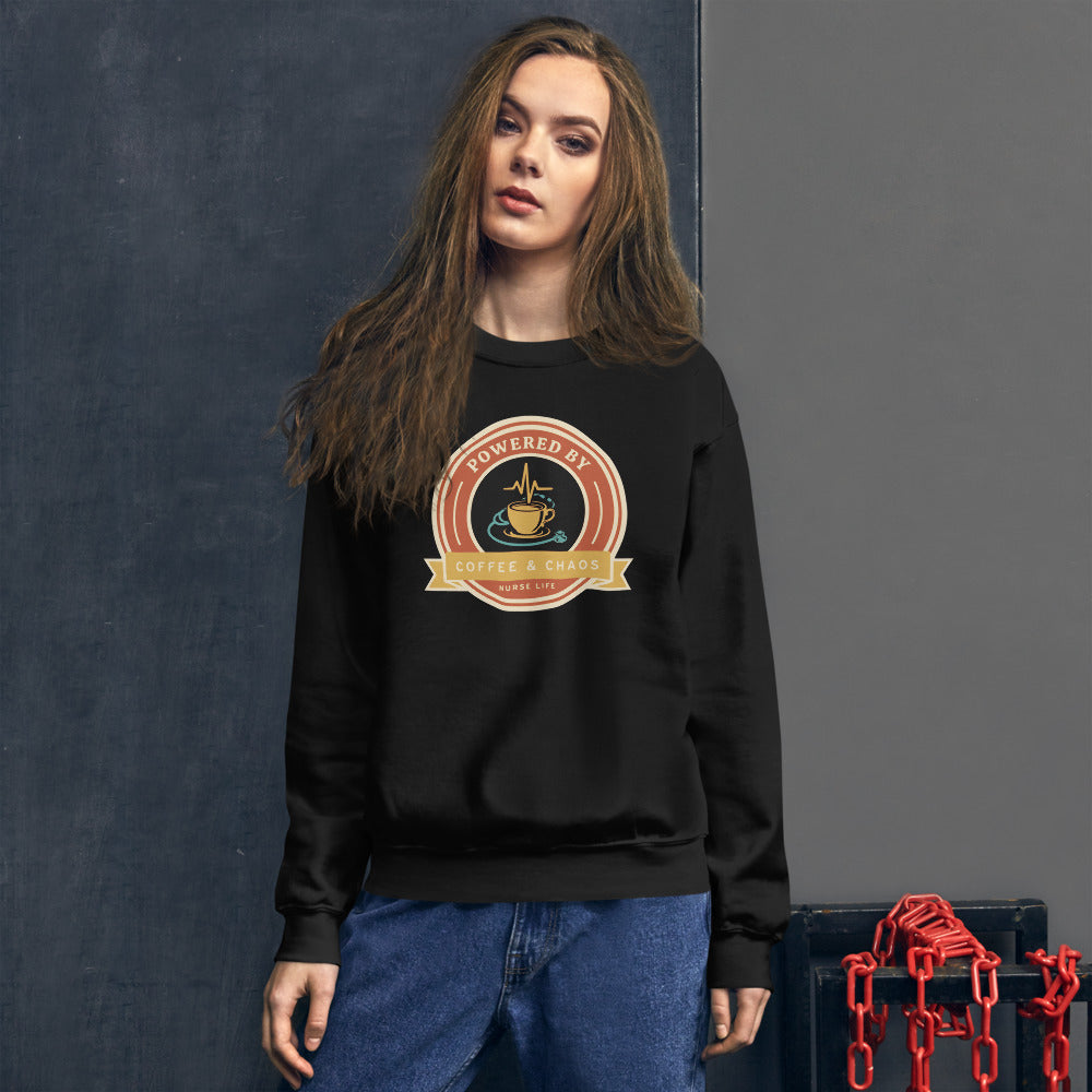 Powered by Coffee & Chaos retro nurse badge crewneck sweatshirt — Black, on model