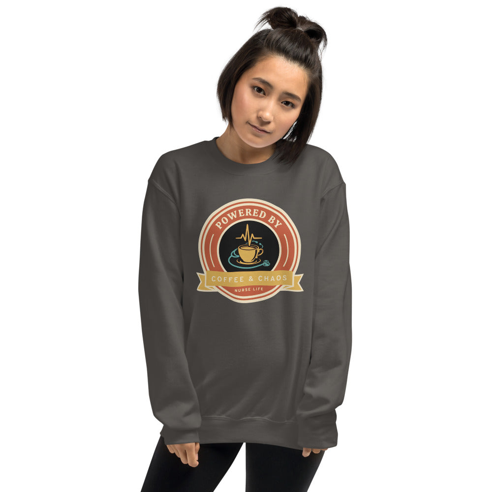 Powered by Coffee & Chaos retro nurse badge crewneck sweatshirt — Charcoal, on model