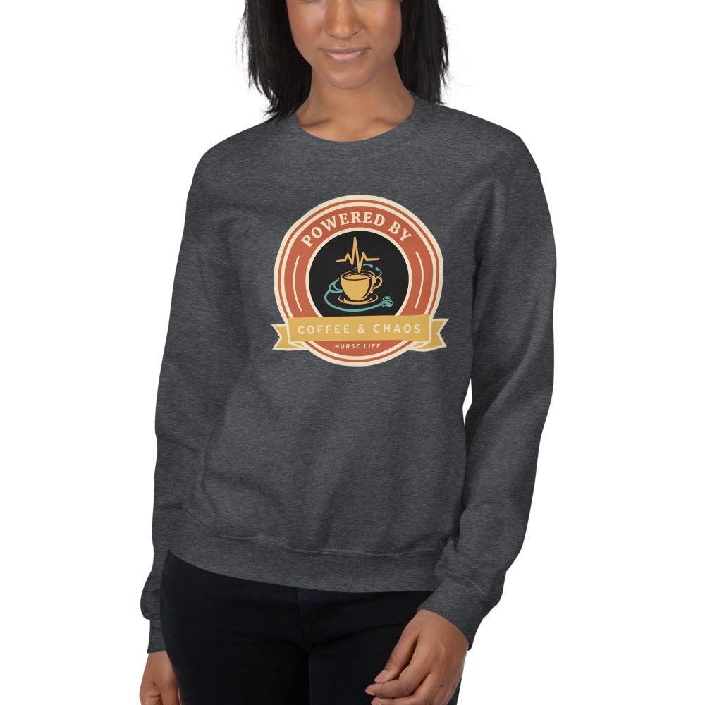 Powered by Coffee & Chaos retro nurse badge crewneck sweatshirt — Dark Heather, on model