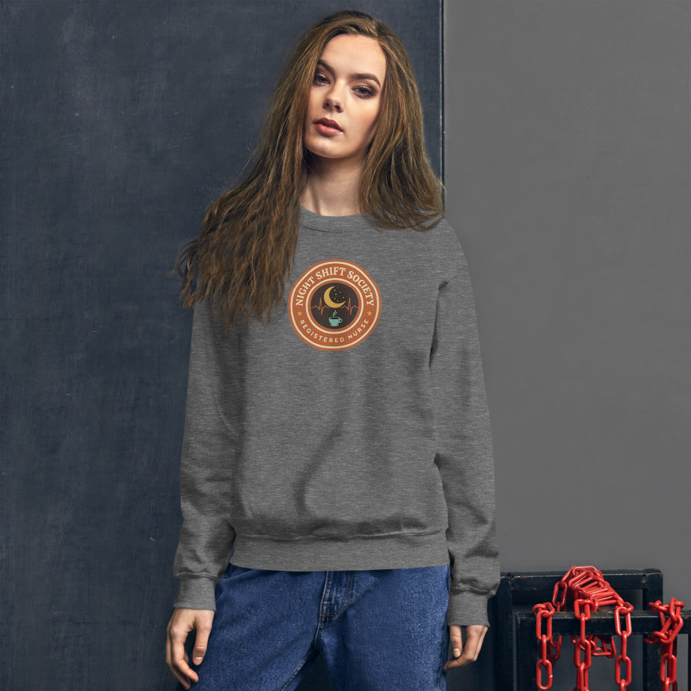 Night Shift Society retro registered nurse badge crewneck sweatshirt — Graphite Heather, on model
