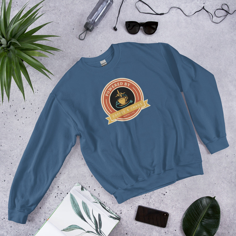 Powered by Coffee & Chaos retro nurse badge crewneck sweatshirt — Indigo Blue, front-right