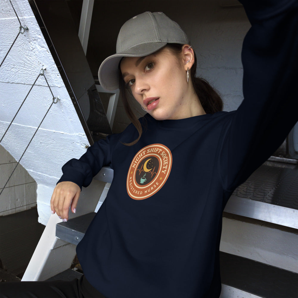 Night Shift Society retro registered nurse badge crewneck sweatshirt — Navy, on model