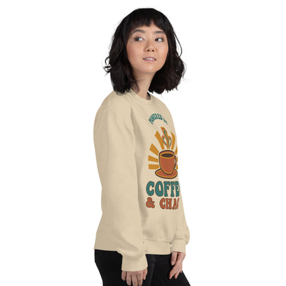 Model wearing Powered By Coffee And Chaos retro groovy teacher crewneck sweatshirt — Sand
