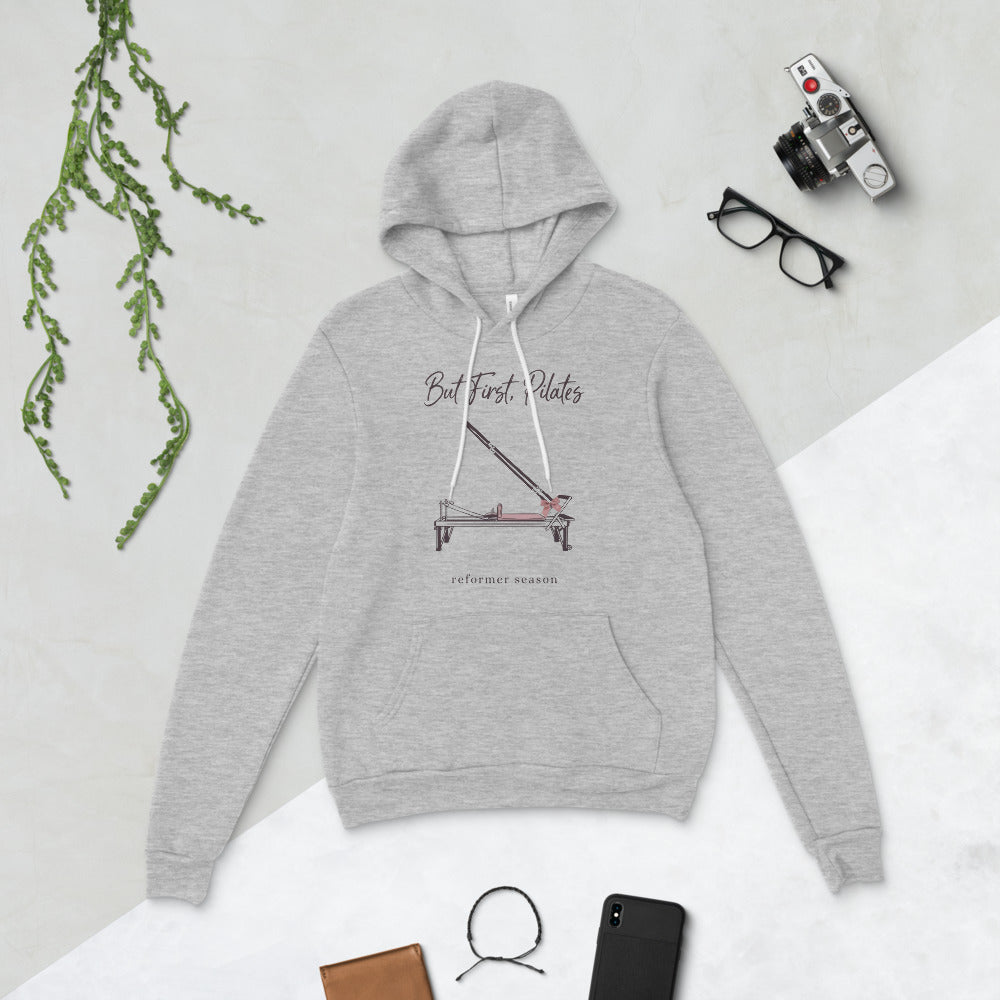 But First Pilates reformer line-art hoodie — Athletic Heather, flat lay