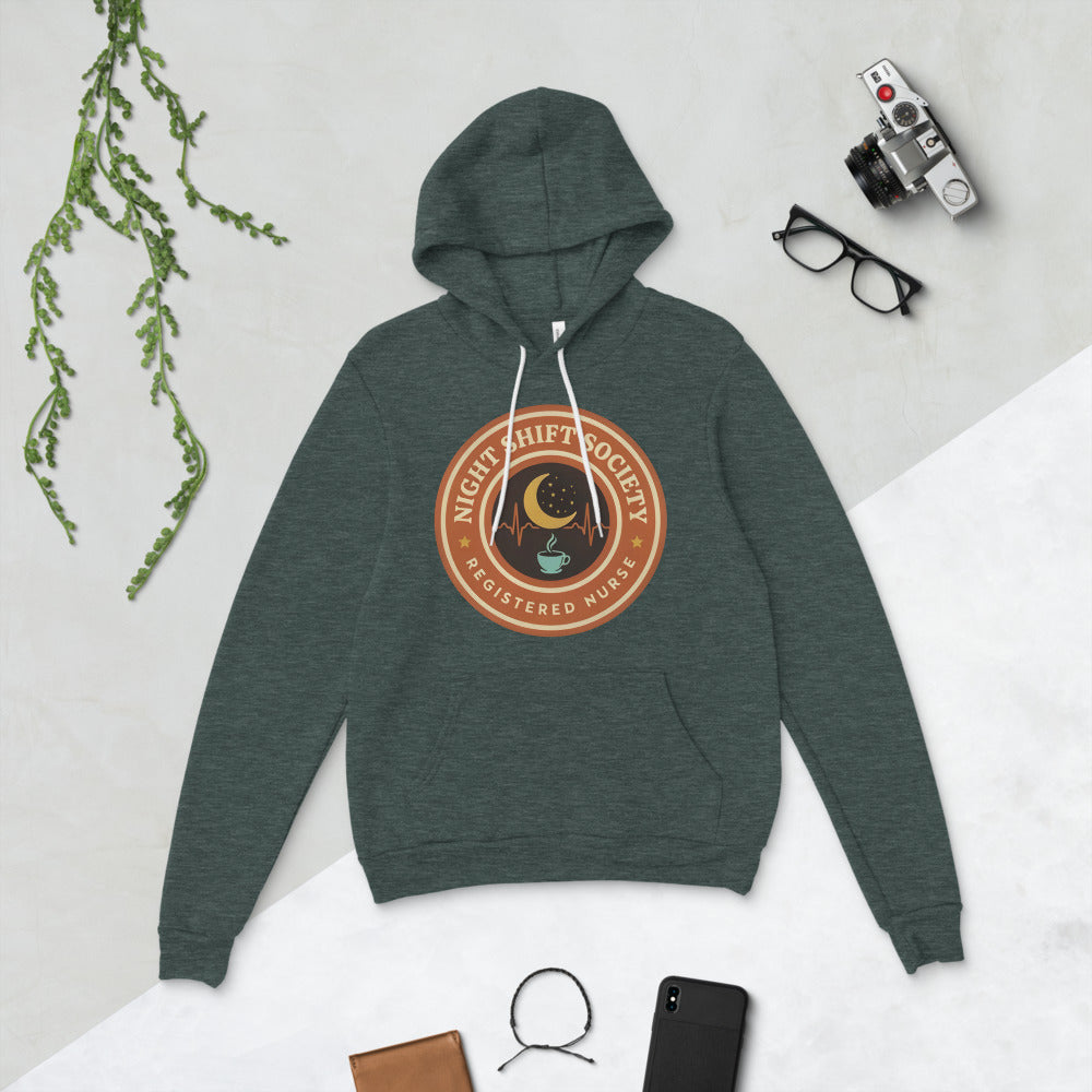 Night Shift Society retro registered nurse badge hoodie — Heather Forest, flat lay
