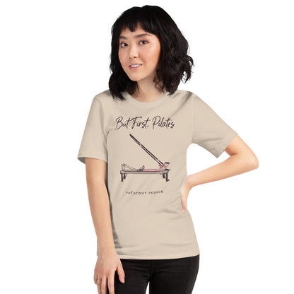 But First Pilates reformer line-art tee — Soft Cream, on model